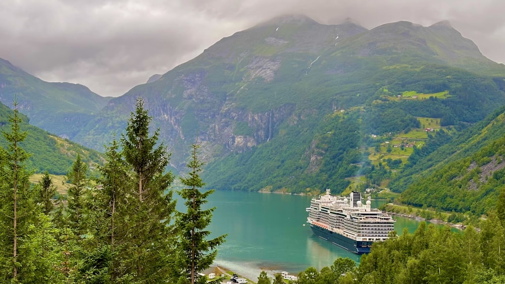 Ein Kreuzfahrtschiff im Wasser, umgeben von Bergen