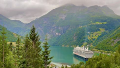 a cruise ship in the water surrounded by mountains