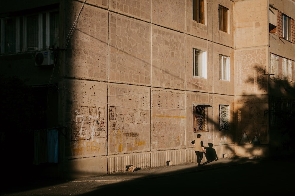 a person sitting on the ground in front of a building