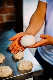Artisan baker carefully shaping dough in a modern bakery setting