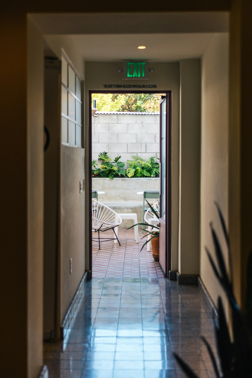 a hallway leading to a patio with a table and chairs