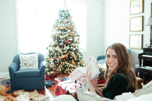 A cozy living room scene with Festa's celebration box opened, revealing colorful decorations, treats, and a glowing QR code.