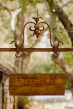 a wooden sign hanging from the side of a building