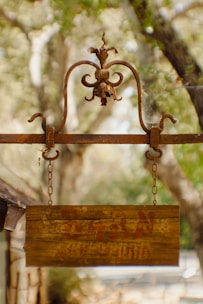 a wooden sign hanging from the side of a building
