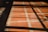 A tiled floor with a red and white grid pattern is partially covered by shadows cast from a window, forming rectangular shapes on the surface.