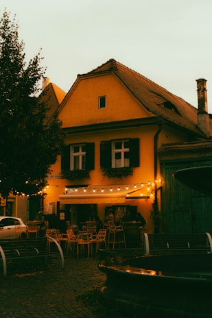 A cozy local café terrace in Ayamonte with warm lighting at sunset.