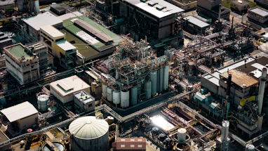 Wide shot of a fuel manufacturing plant showing large pipelines connected to valves and sensors.