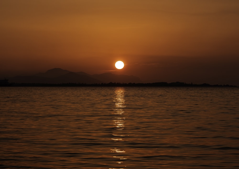 El sol se está poniendo sobre un cuerpo de agua