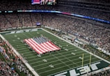 a football field with a large american flag on it