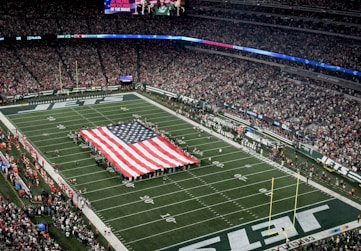 a football field with a large american flag on it