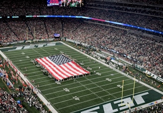 a football field with a large american flag on it