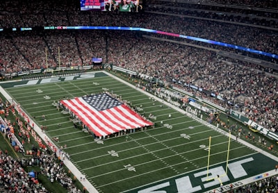 a football field with a large american flag on it