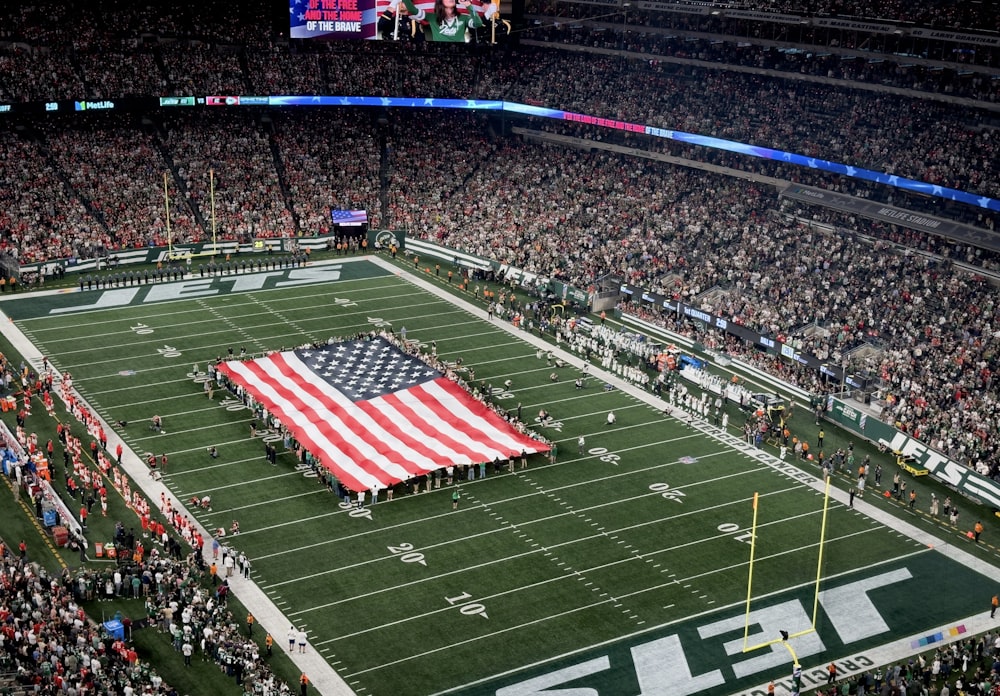a football field with a large american flag on it