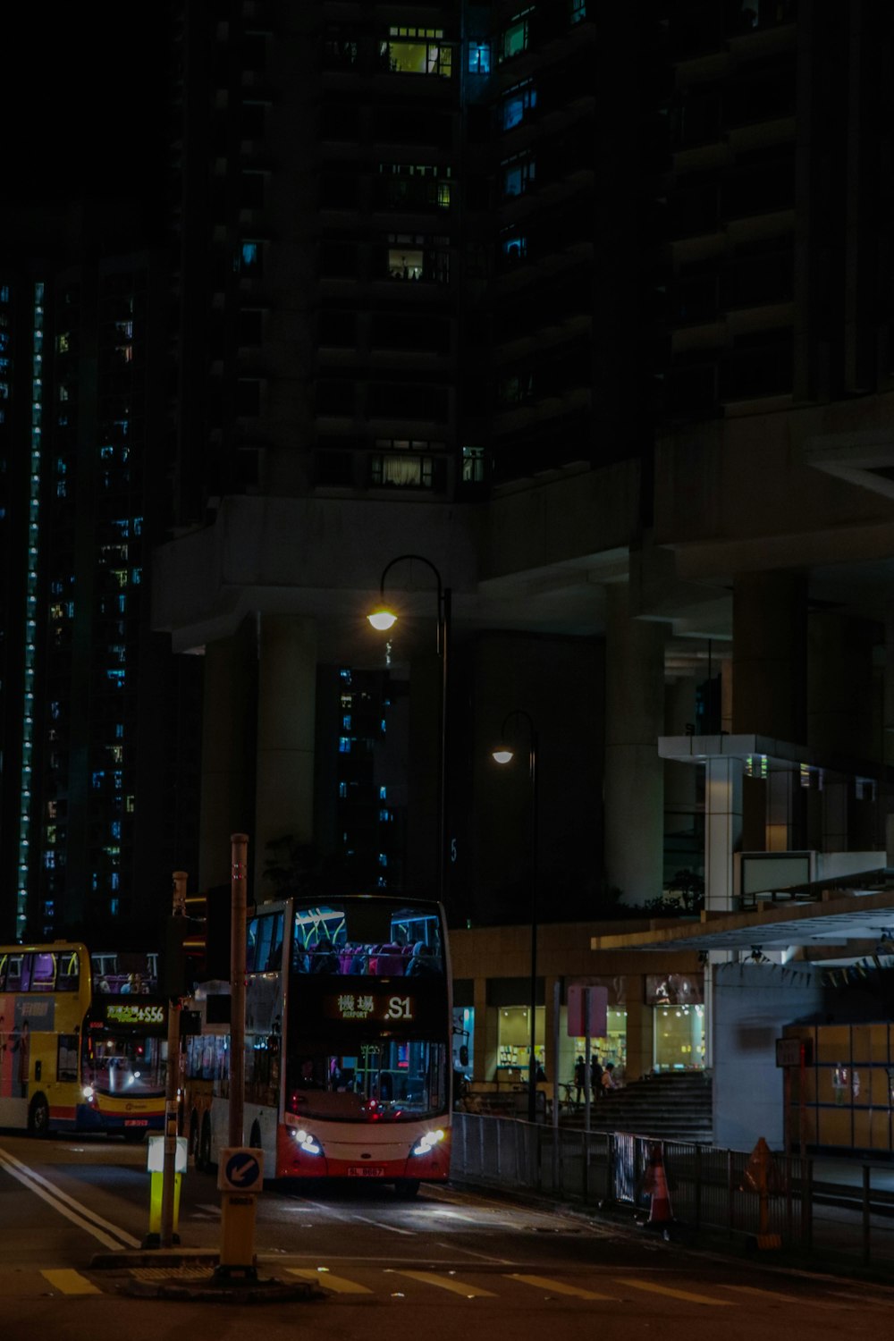 a double decker bus driving down a street at night