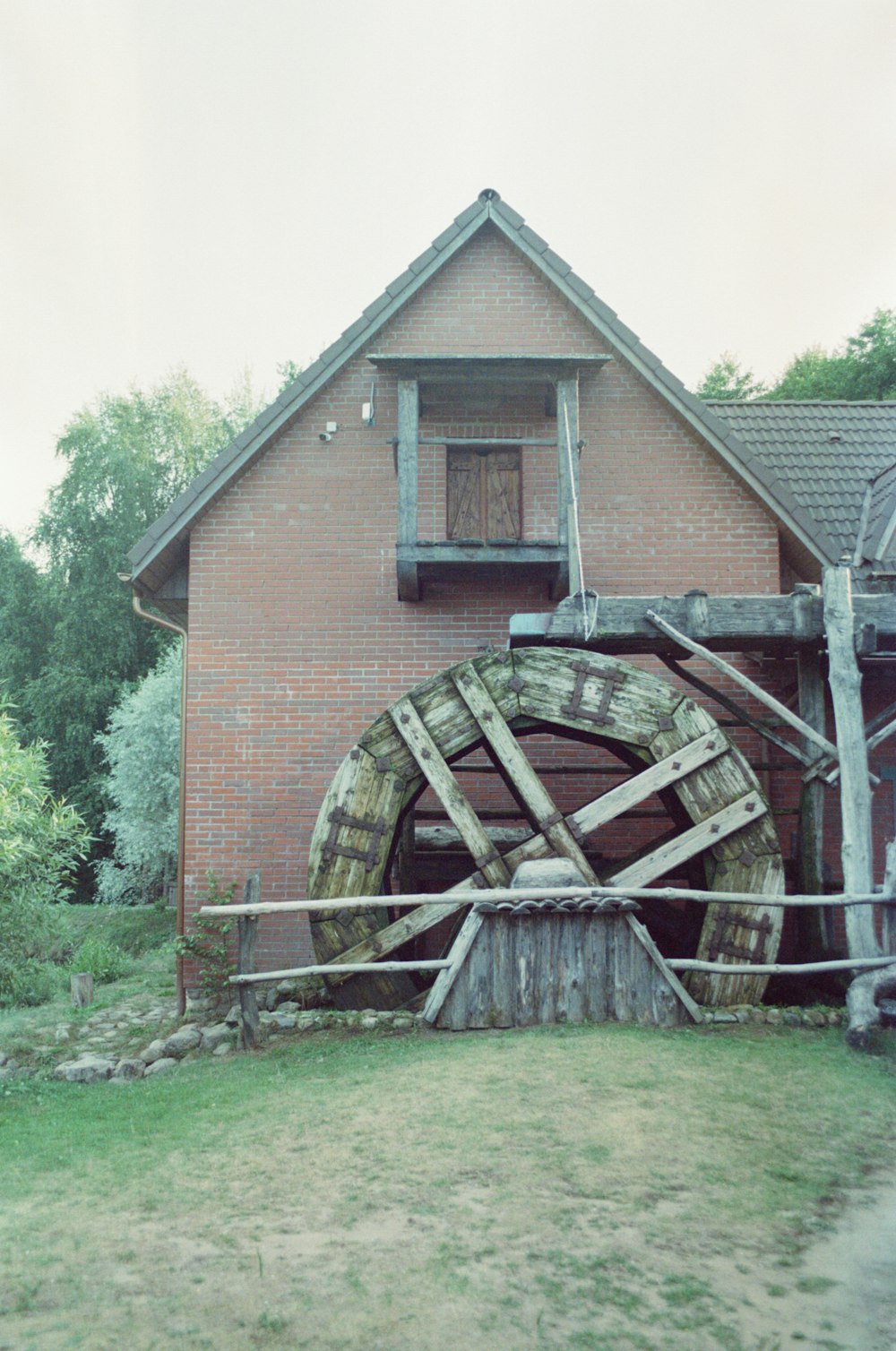 a water wheel in front of a brick building