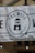 A banner displaying a logo with the text 'THE WELL' and an image of a water well with a droplet. The banner indicates the establishment has been serving Sheffield since 2015. It is mounted on a stone building and features decorative light bulbs hanging in front of it.