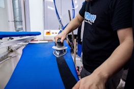 a man is using a sanding machine on a blue surface