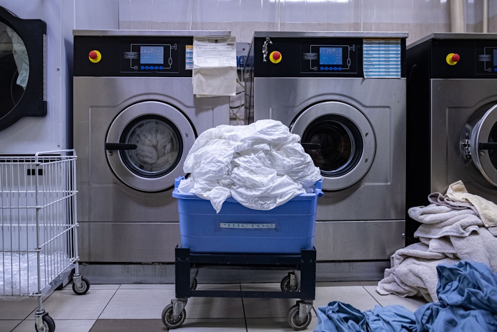 un lavadero con lavadora y cesta de la ropa sucia