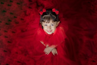A quinceañera smiling brightly in a vibrant dress surrounded by family and friends.