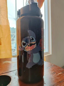 Colorful kids lunch boxes and cartoon water bottles arranged neatly on a wooden table.