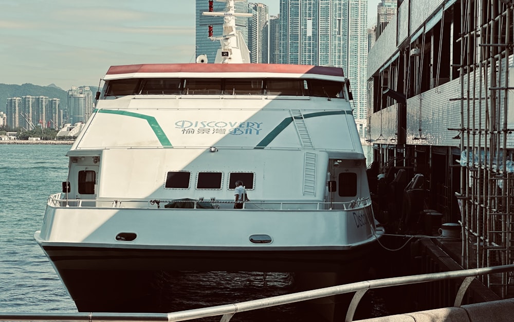 a large white boat in the water near a dock