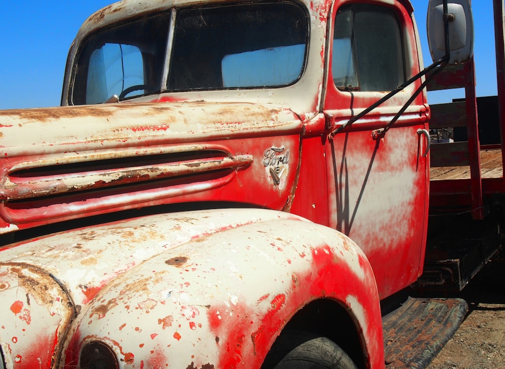 an old red truck parked in a field