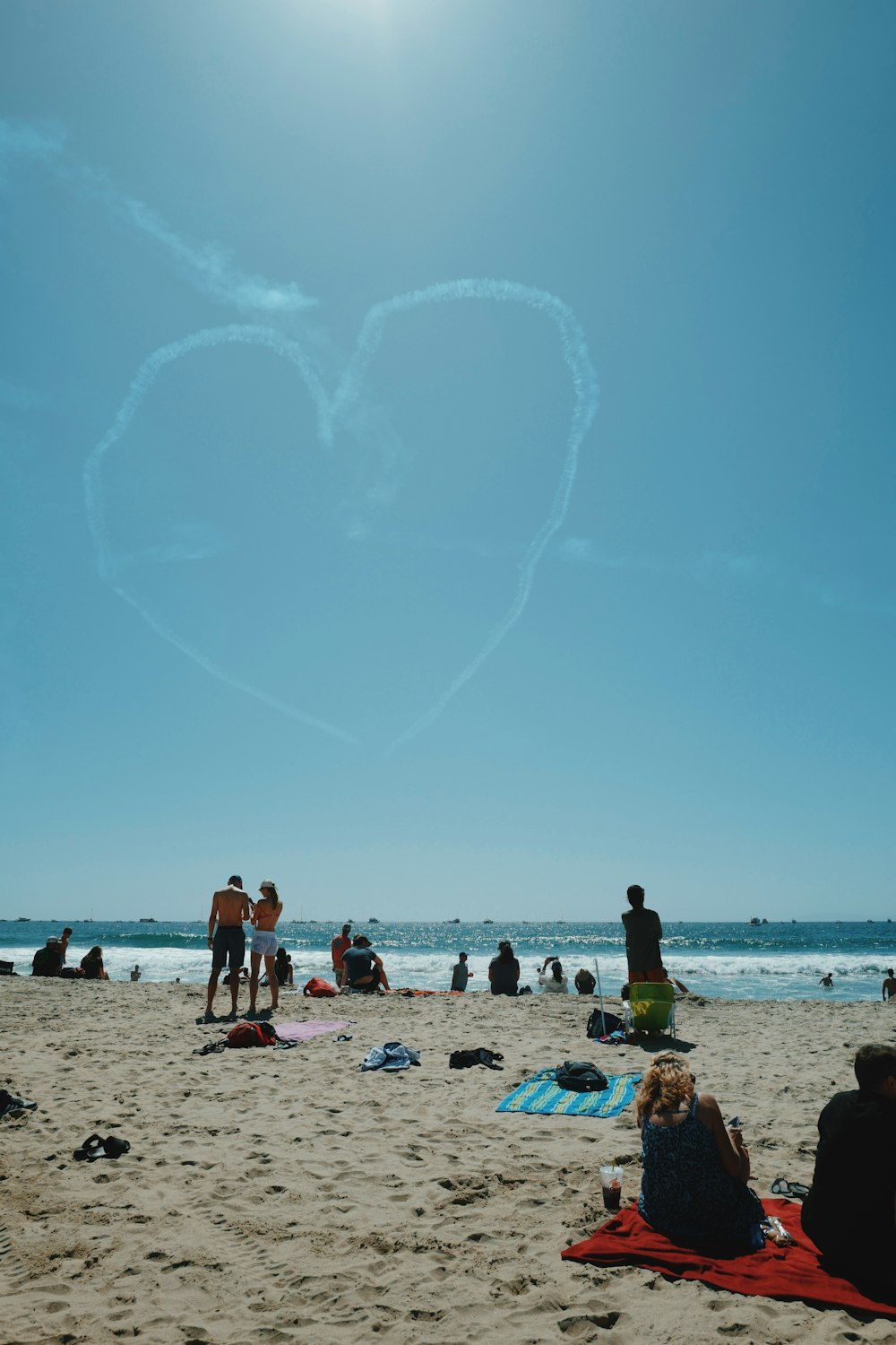 a group of people sitting on top of a sandy beach