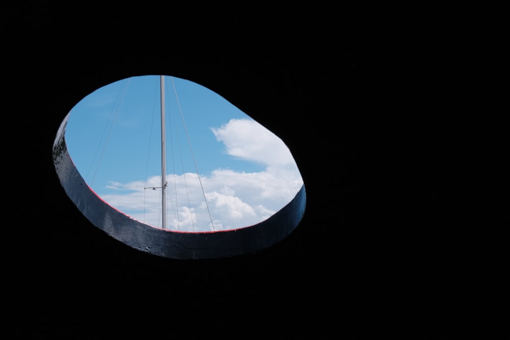 a sailboat is seen through a circular window