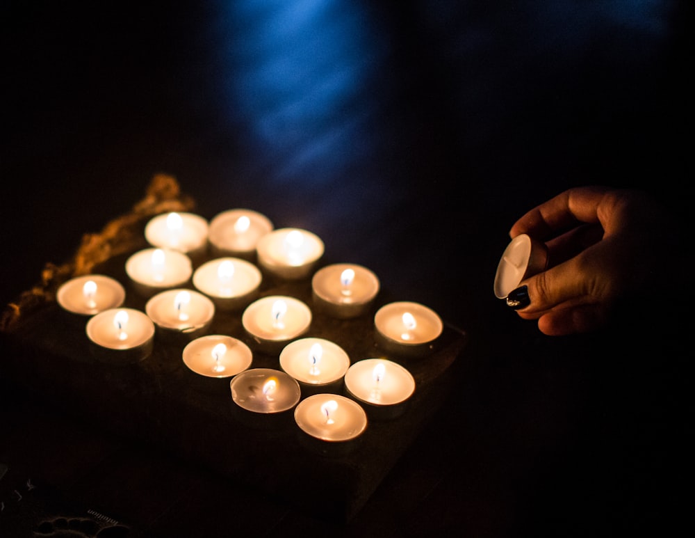 a person lighting candles in a dark room