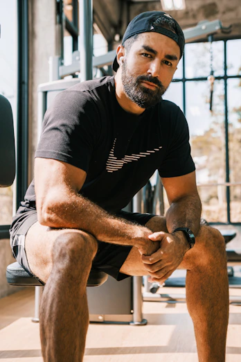 a man sitting on a bench in a gym