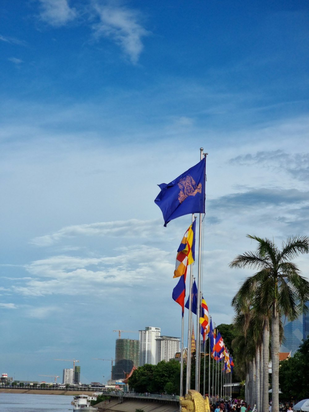 a group of flags flying next to a body of water