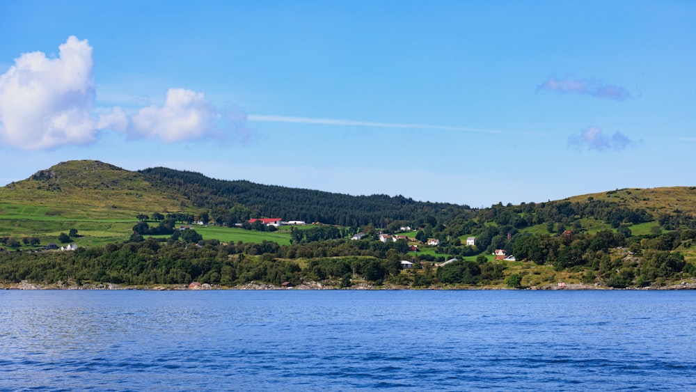 a body of water with a hill in the background