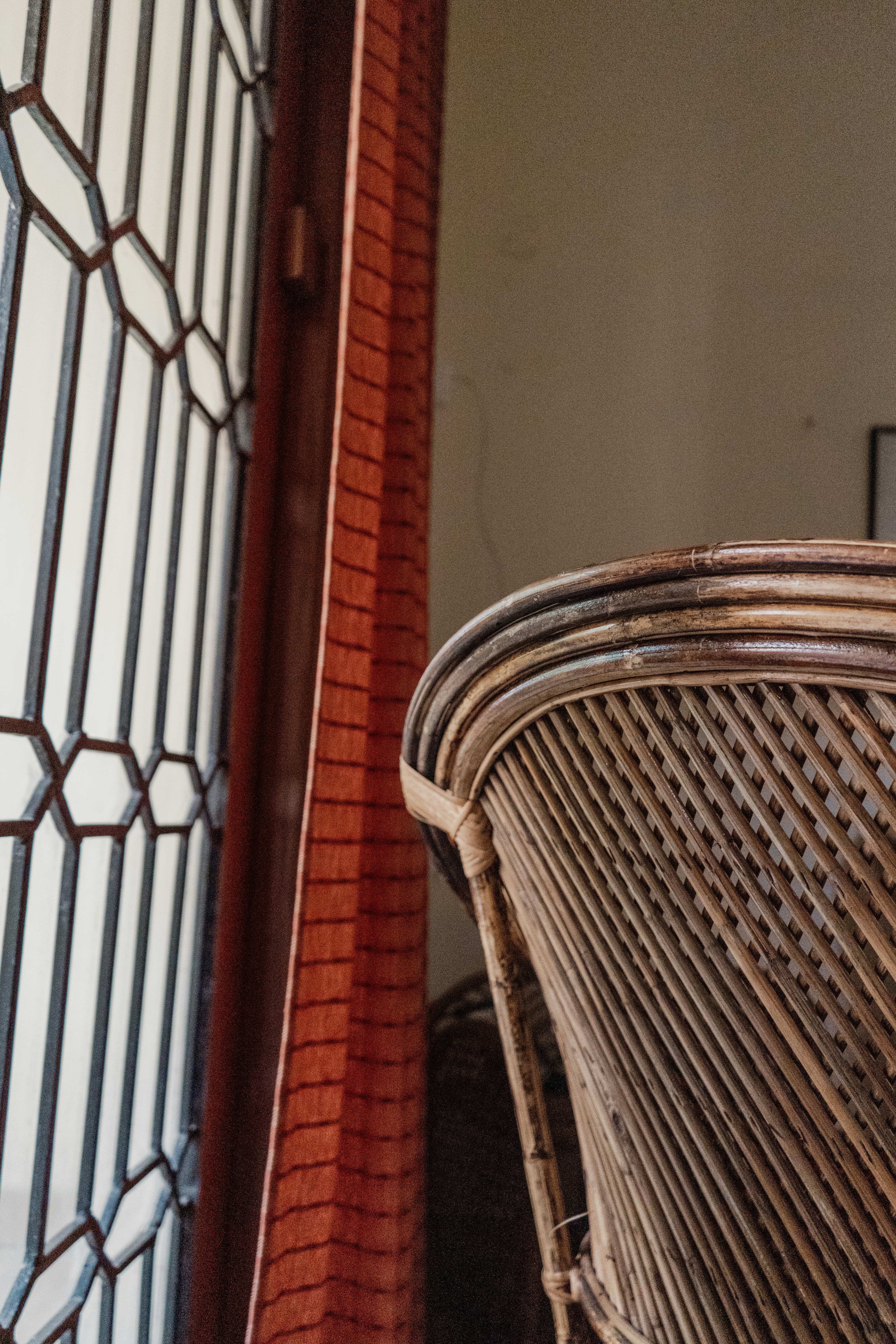 a close up of a wicker chair near a brick wall
