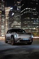 A nighttime shot of the Cadillac Escalade with city lights reflecting off its glossy surface.