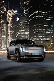 Sleek black luxury SUV parked in Denver cityscape at dusk with electric blue highlights.