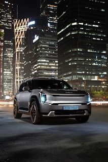 A sleek commercial vehicle photographed at dawn with city skyline in the background, emphasizing modern design.
