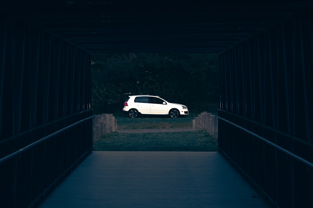 a white car is parked in a dark tunnel