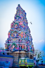 a very tall colorful building with a bus parked in front of it