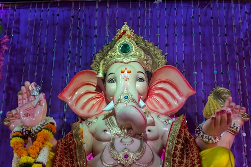 Hands of devotees receiving hot freshly made modaks during a Ganesh festival celebration.