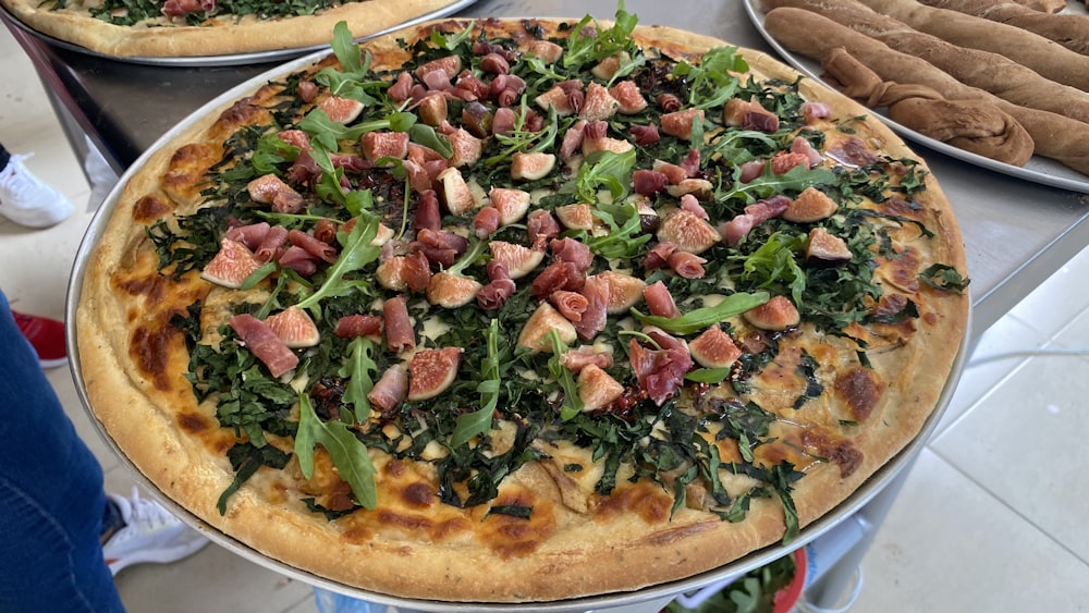 two pizzas with different toppings sitting on a table