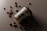 A biodegradable coffee cup with a black lid is tilted on its side on a dark surface. Scattered around the cup are several coffee beans that create a visually appealing arrangement.