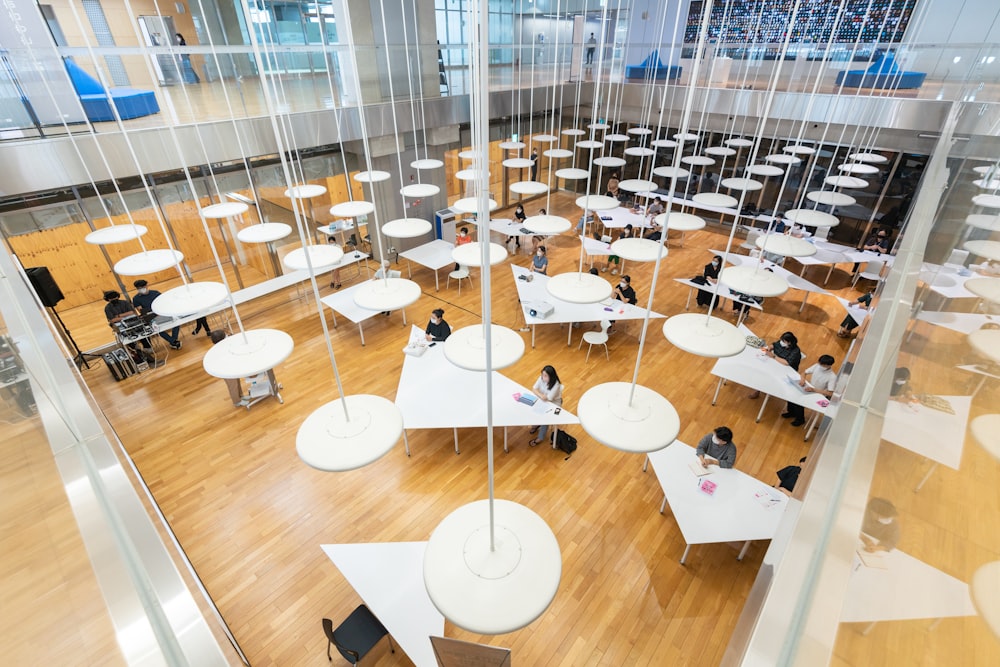 a room filled with lots of white tables and chairs