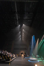 A sleek keynote stage with spotlight shining, ready for a speaker.