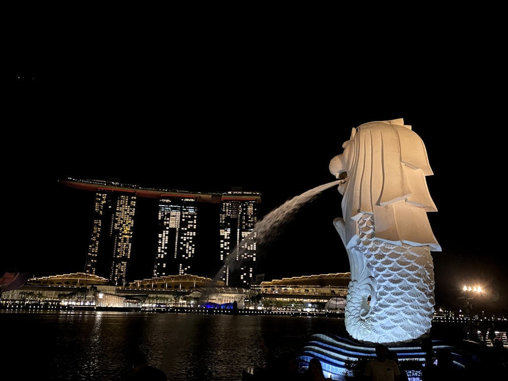 a large statue of a fish in the middle of a body of water