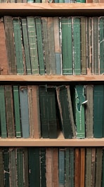 An old library shelf filled with aged books and manuscripts.