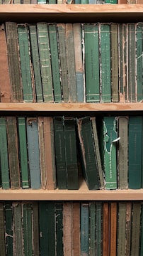 An old library shelf filled with worn books on anthropology and mysticism.