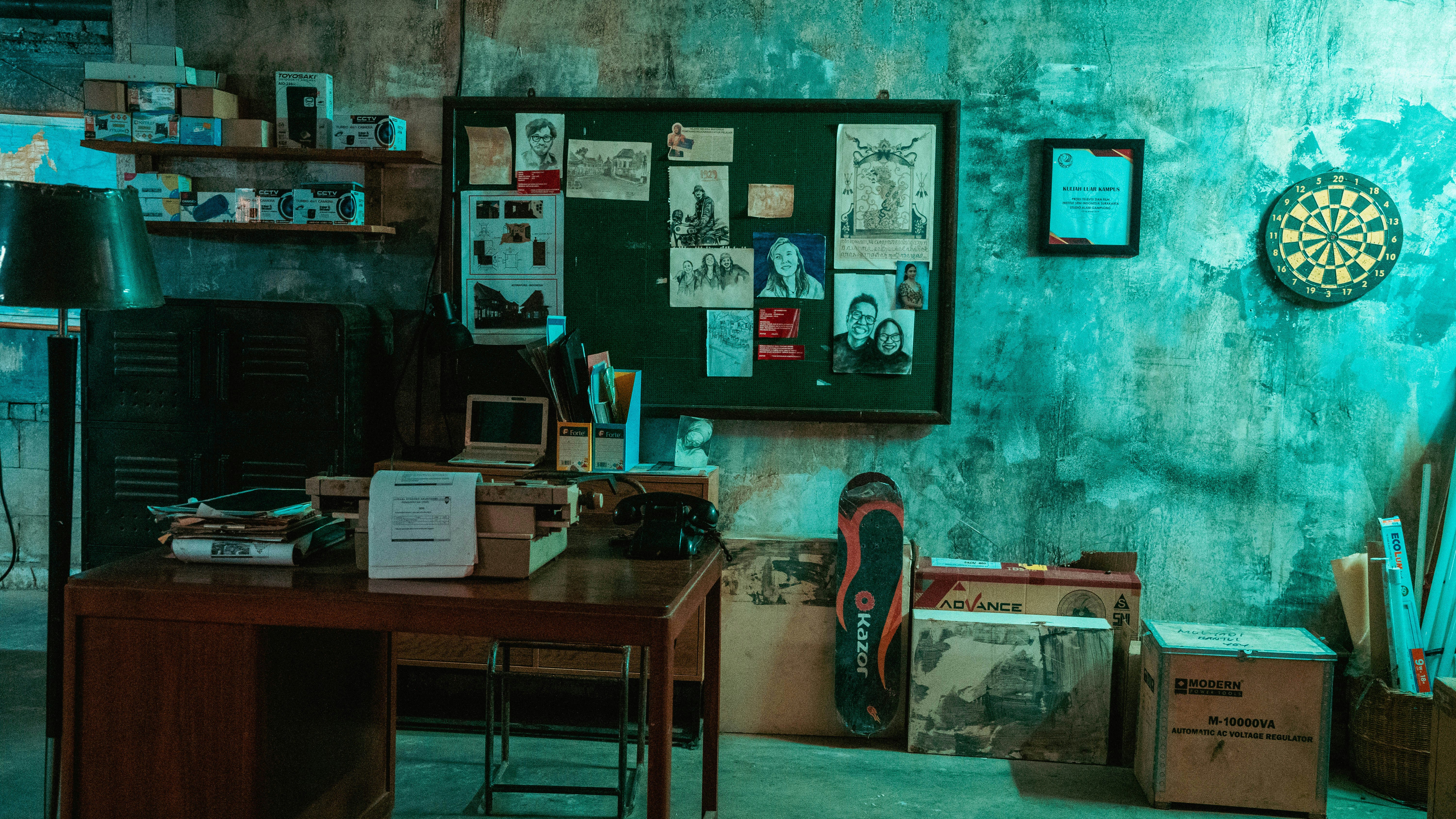 a room with a wooden desk and a green wall