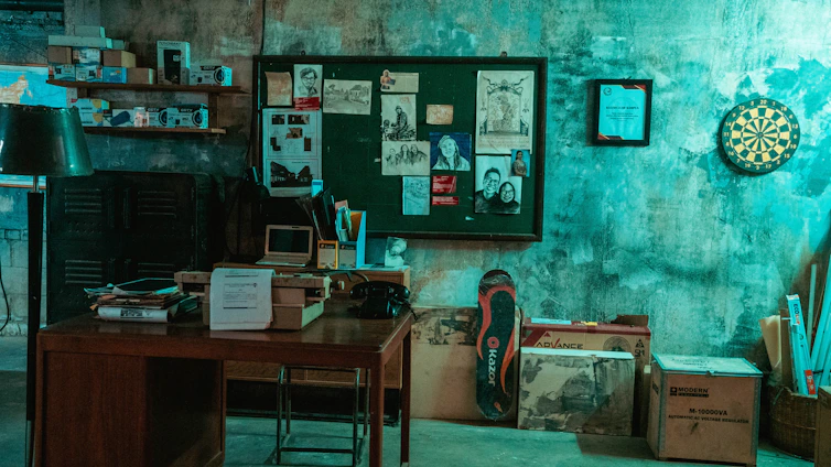 A dimly lit room with scattered clues, a magnifying glass, and a vintage typewriter hinting at a cold case mystery.