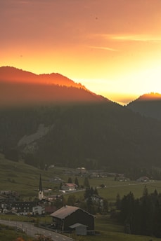 A serene sunrise over a peaceful village symbolizing hope and faith.