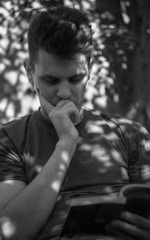A thoughtful veteran reading a book outdoors